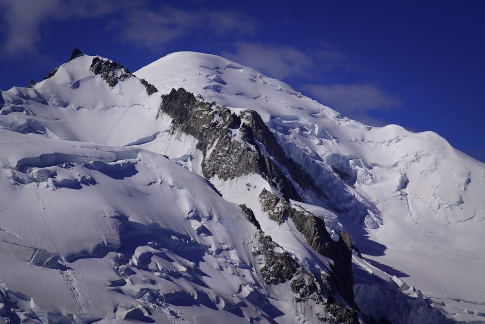 a large mountain covered in snow under a blue sky