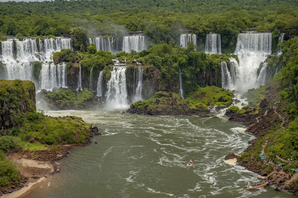 a large waterfall with a boat in the middle of it