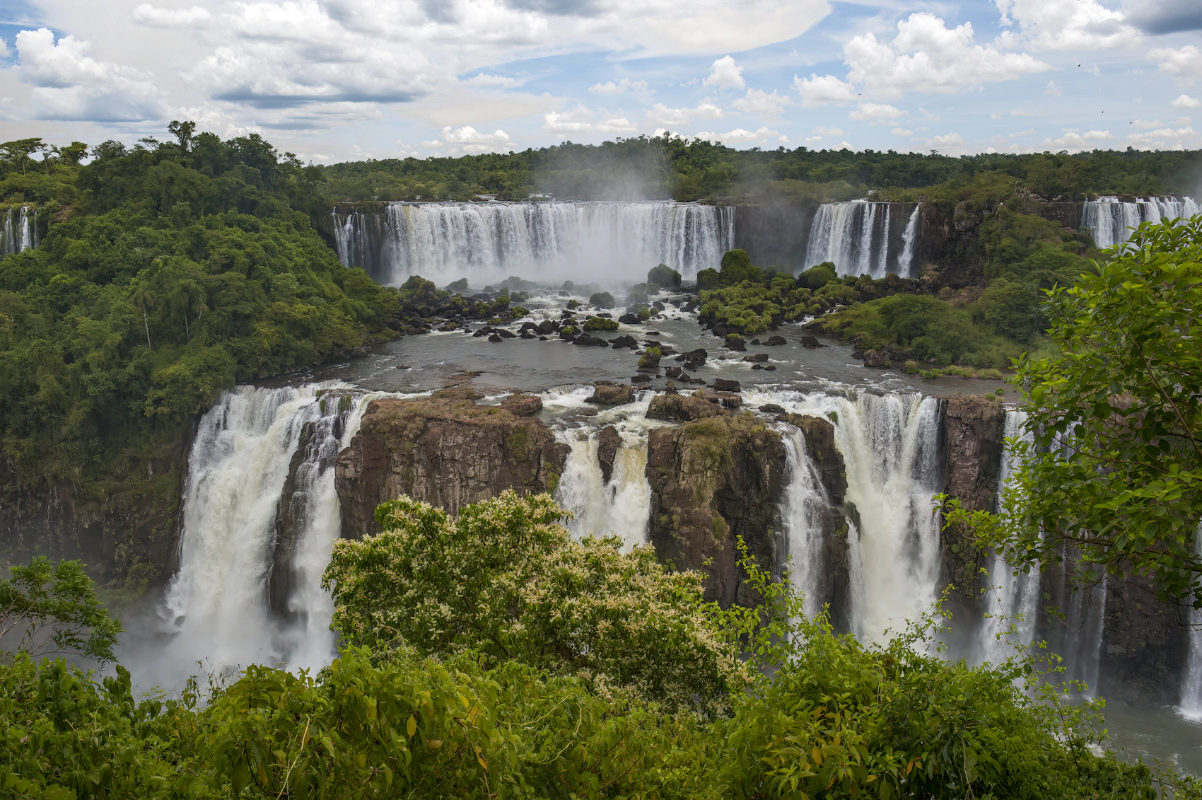 Iguaçu Falls cascading through dense green forest