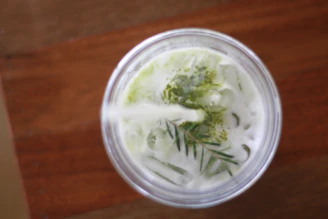 Close-up of a refreshing Thai iced tea topped with creamy foam and a sprinkle of spices.