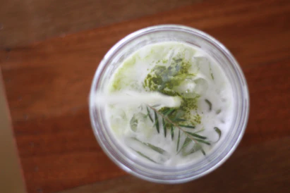 Close-up of a refreshing Thai iced tea topped with creamy foam and a sprinkle of spices.
