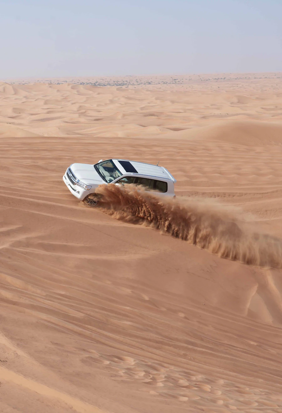 Vehicle driving through desert sand dunes