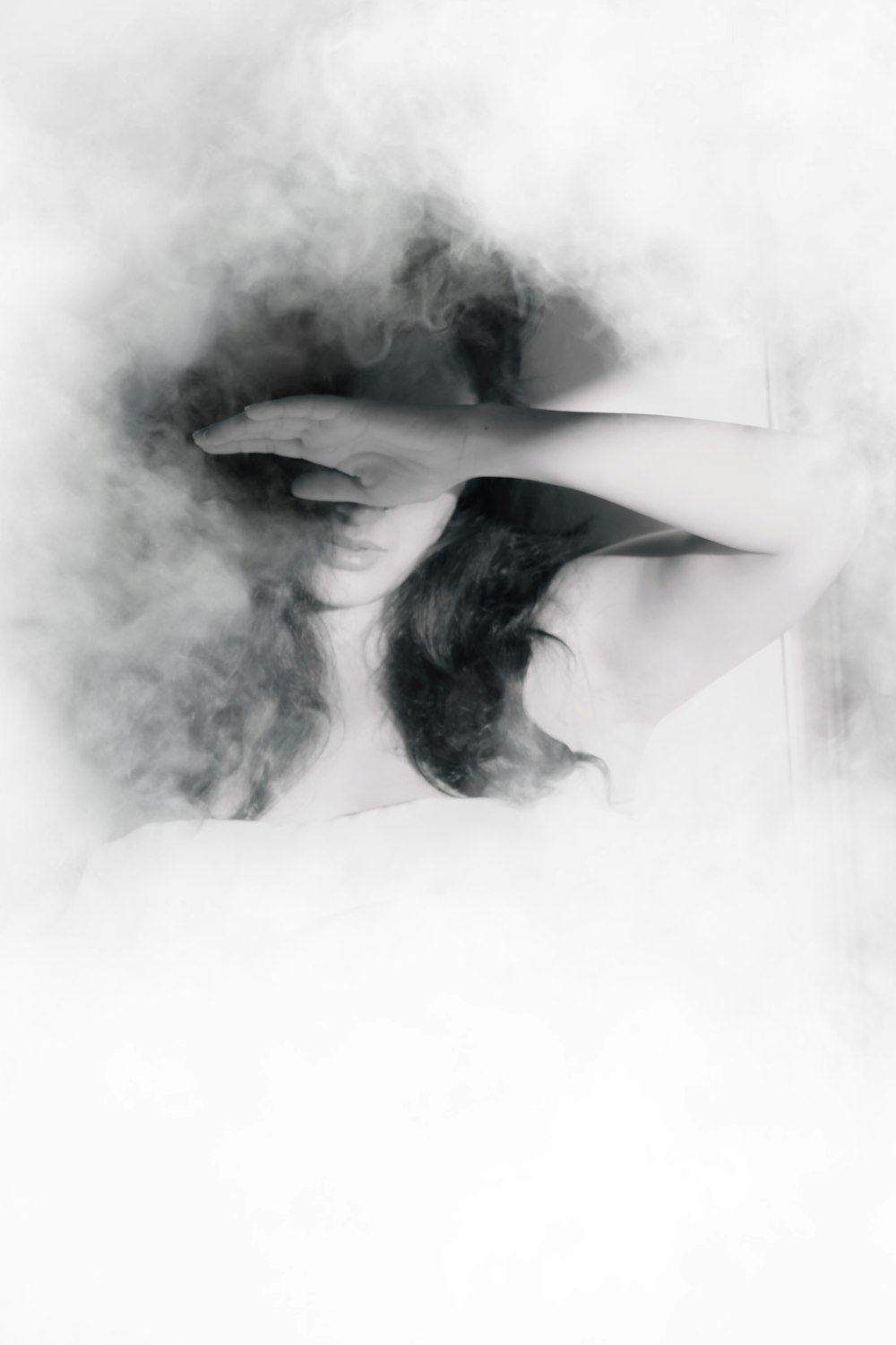 a woman with long hair standing in smoke