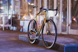 A sleek modern electric bike parked by a city sidewalk at sunset.