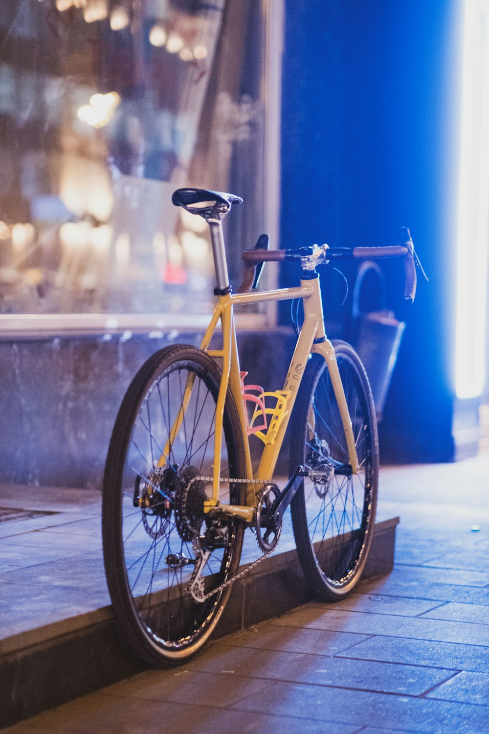 a yellow bike parked on the side of a street