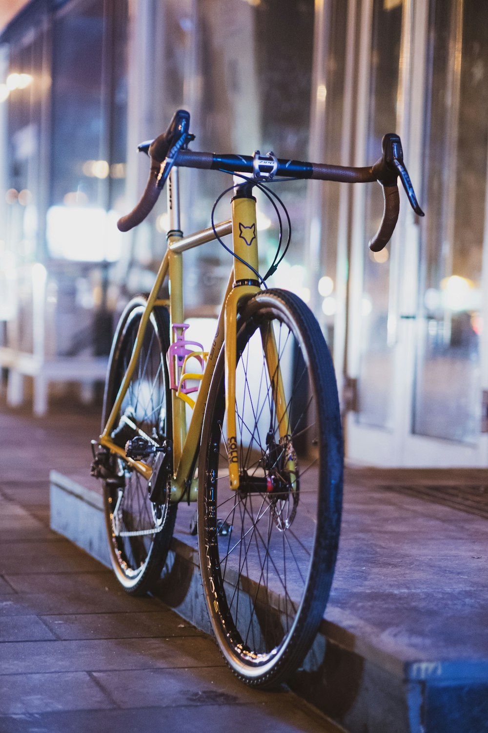 Una bicicleta amarilla estacionada al costado de una calle