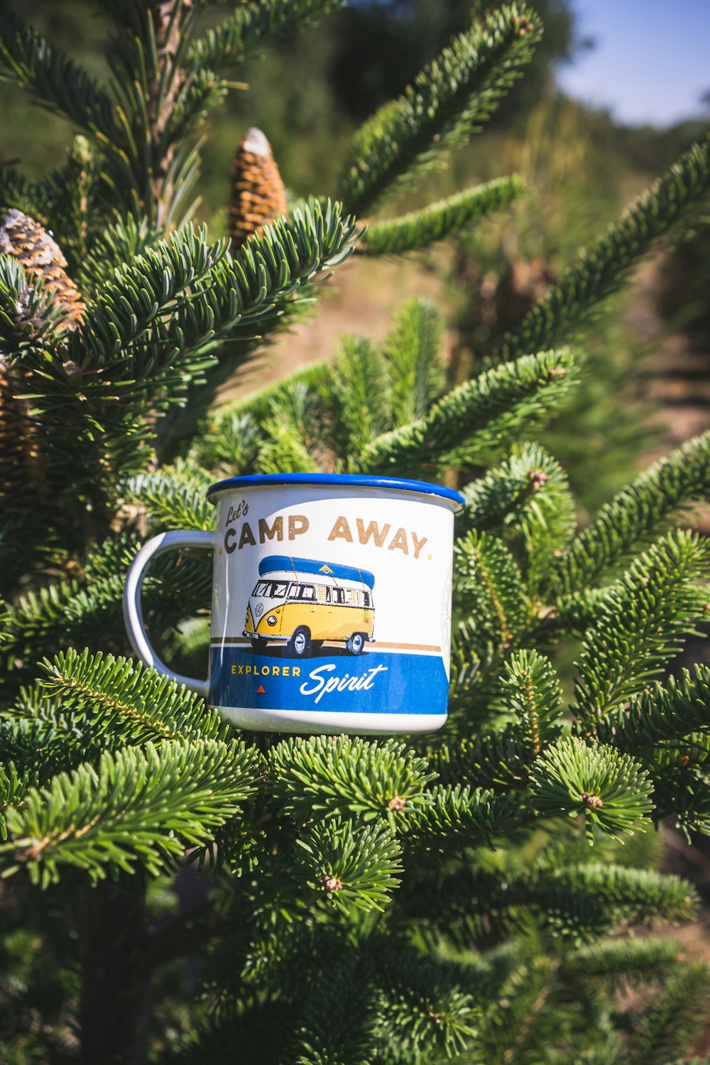 a camp away mug hanging from a tree