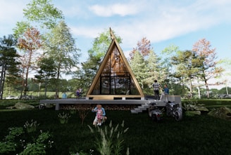 A triangular-shaped wooden house is set in a lush, green forest area. Several people are visible around the house, including a person on a motorcycle and a child playing on the grass. The house has large glass windows and is elevated with steps leading up to it.