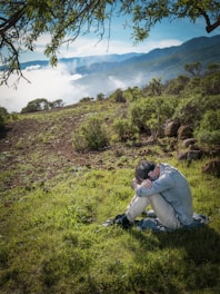 a man sitting on the ground with his head in his hands