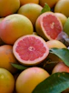 a pile of grapefruits with one cut in half