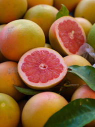 a pile of grapefruits with one cut in half