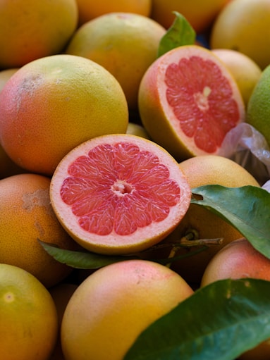 a pile of grapefruits with one cut in half