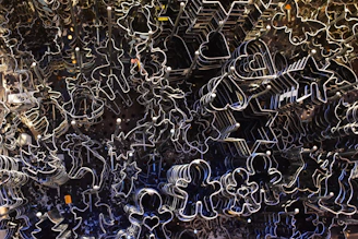 Artisanal cookie cutters arranged on a textured beige fabric background with soft natural light.