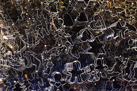 Artisanal cookie cutters arranged on a textured beige fabric background with soft natural light.