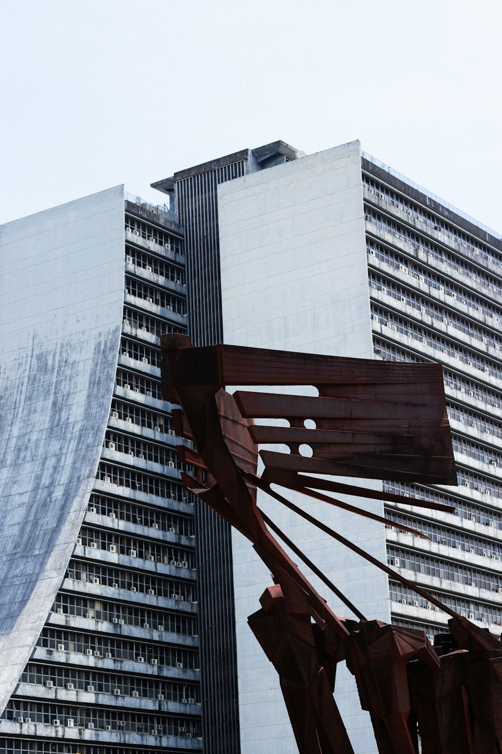Una grande scultura in metallo di fronte a un edificio alto
