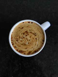 Macro shot of swirling coffee vapor rising delicately from a dark ceramic cup