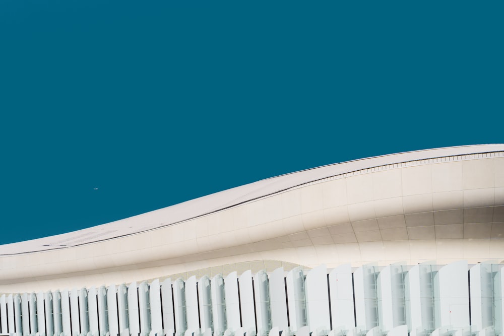 an airplane is flying in the sky over a building