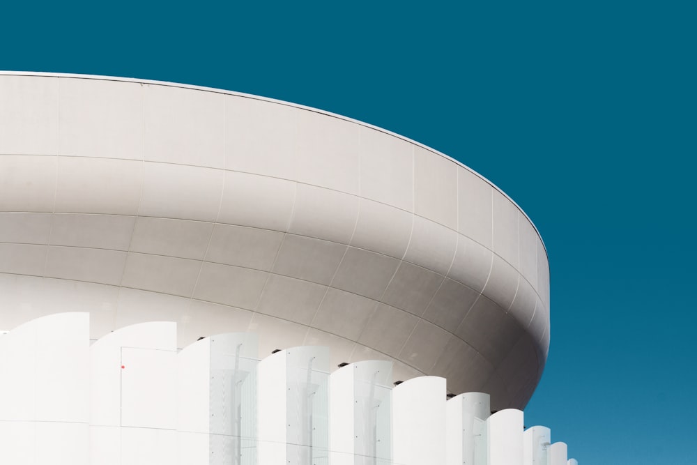 an airplane is flying over a white building