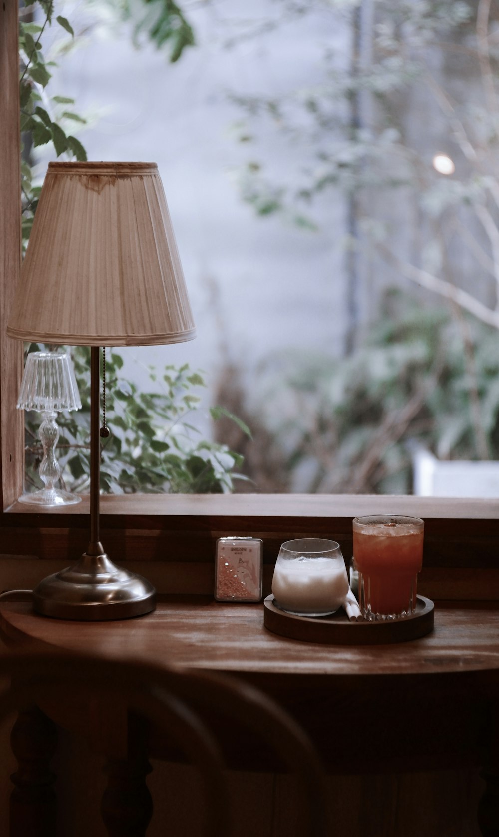 a table with a lamp and some drinks on it