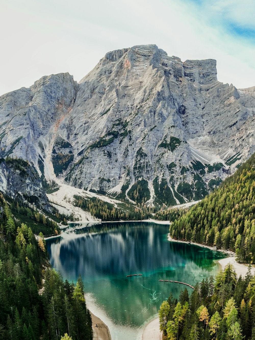 a mountain range with a lake surrounded by trees