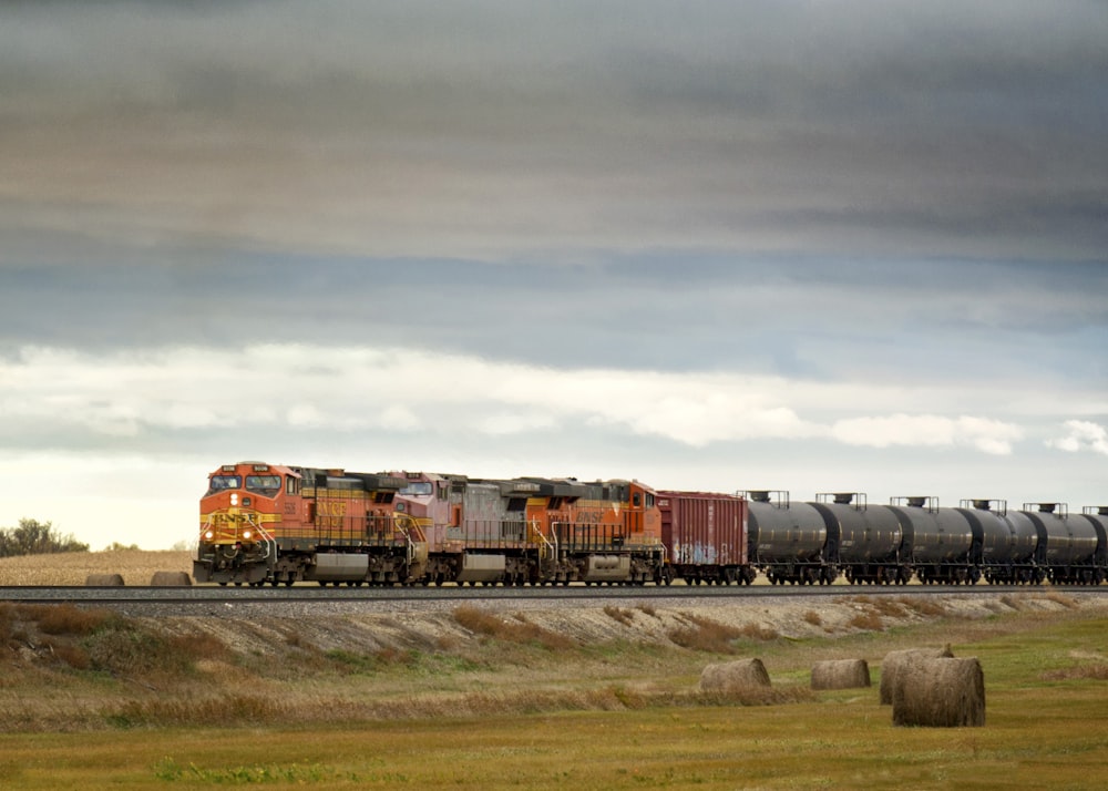 a train traveling down train tracks next to a field