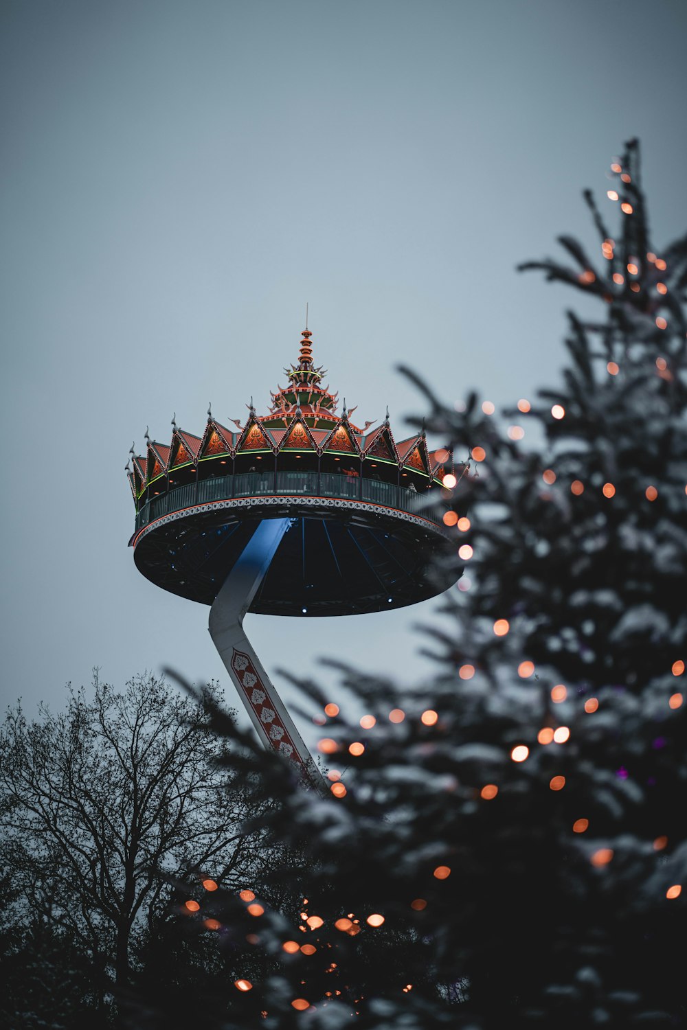 Un árbol de Navidad con una torre al fondo