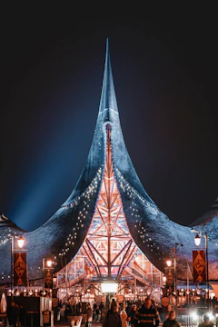 A vibrant circus tent lit up at dusk, symbolizing energy and excitement.