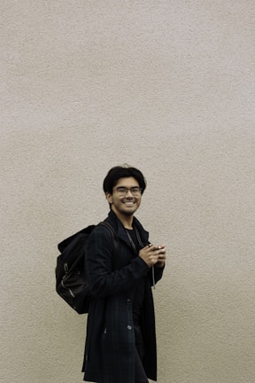 a man standing in front of a white wall