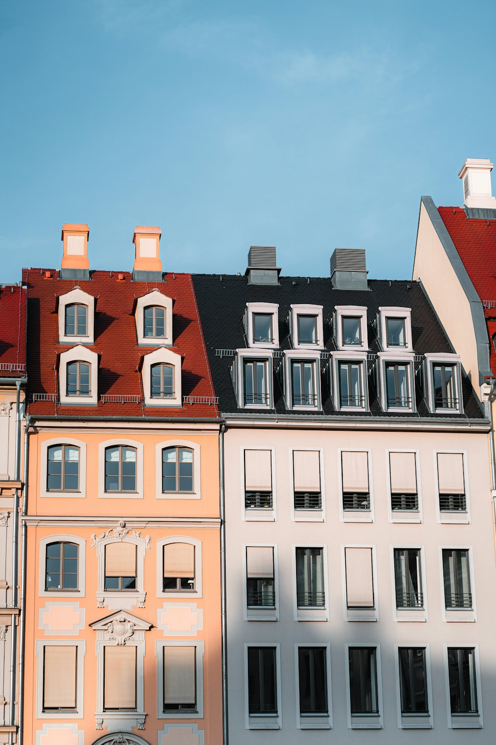 a row of multicolored buildings with a clock on each of them