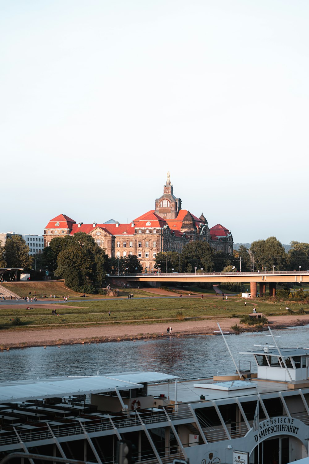 a large building sitting on top of a river next to a bridge