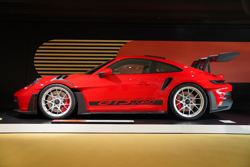 a red sports car on display in a showroom