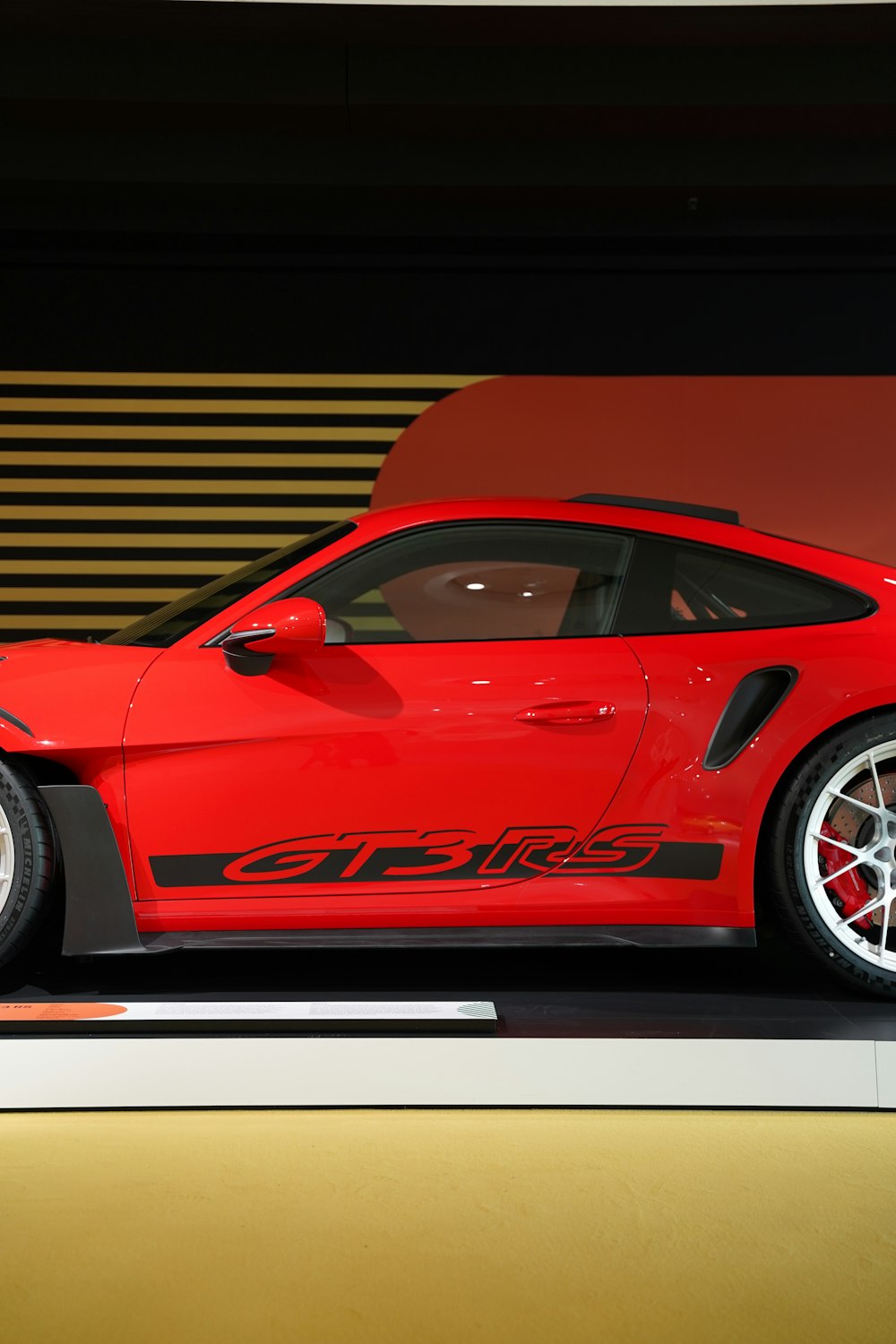 a red sports car on display in a showroom