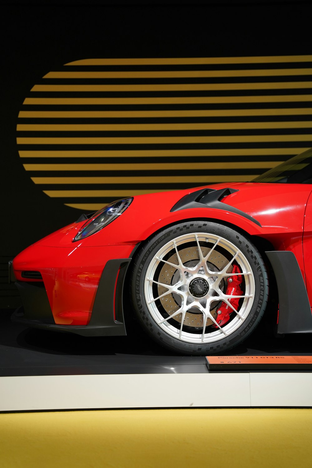 a red sports car parked in front of a wall