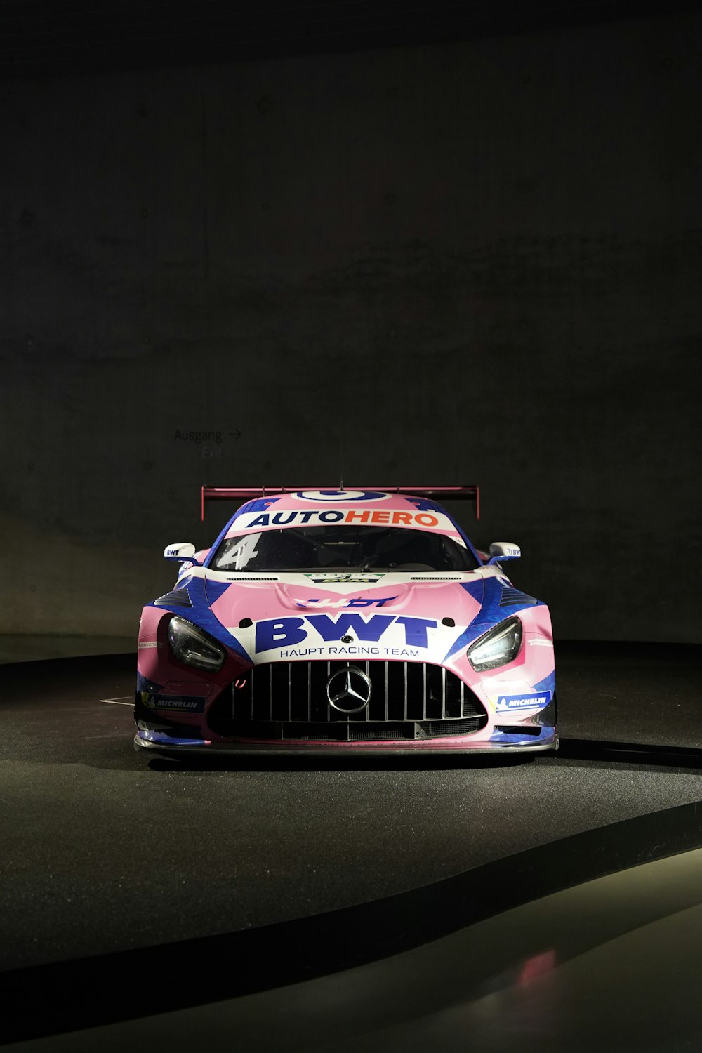 a pink and blue car in a dark room