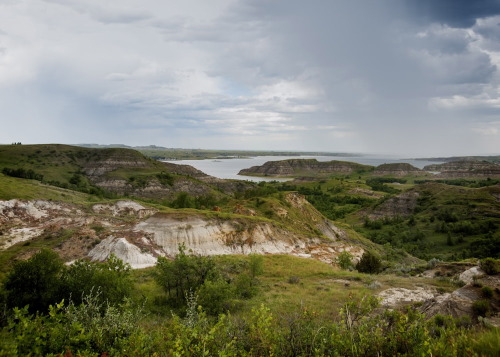 a large body of water sitting on top of a lush green hillside