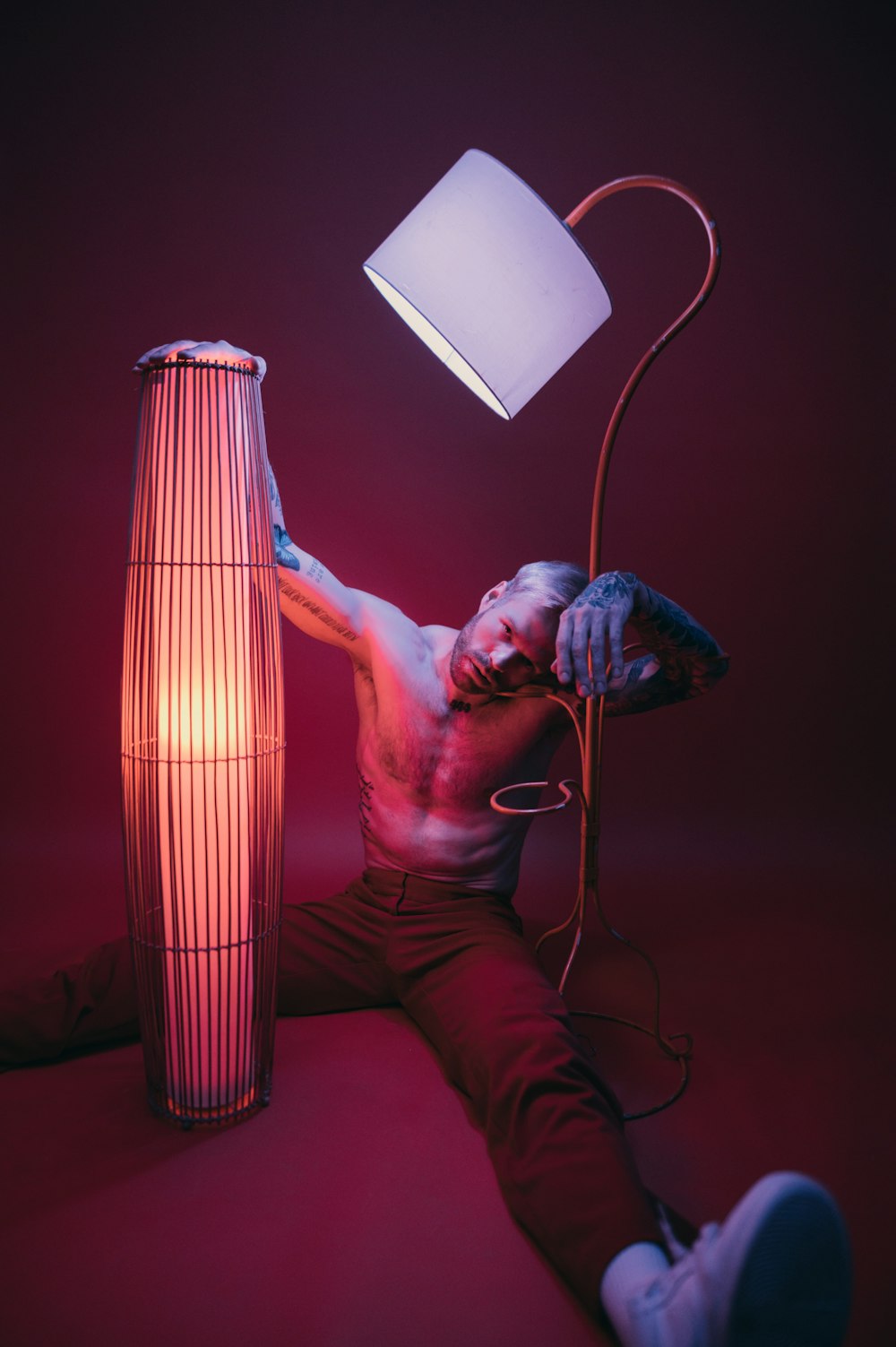 a man laying on the ground next to a lamp