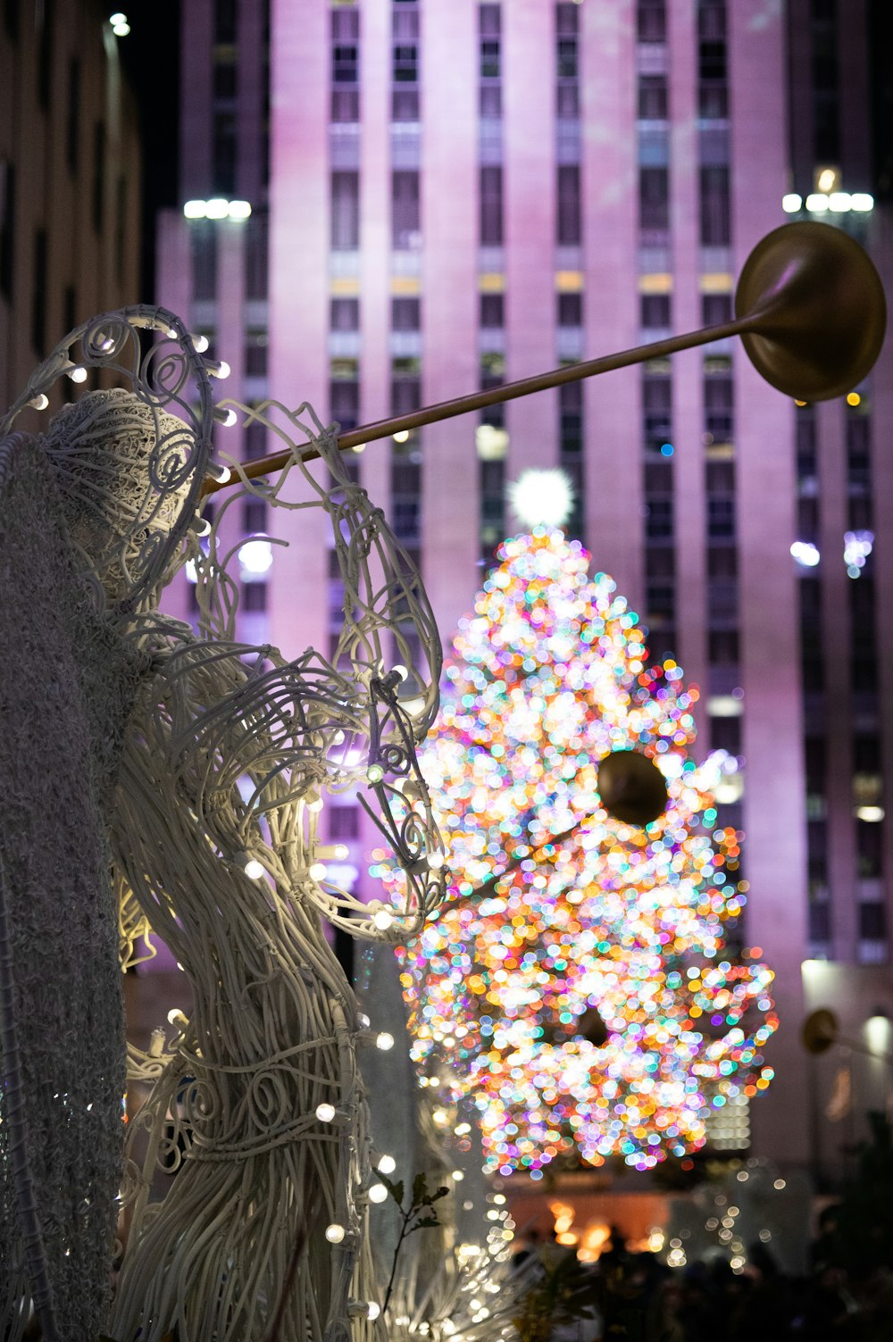 a lighted christmas tree in the middle of a city