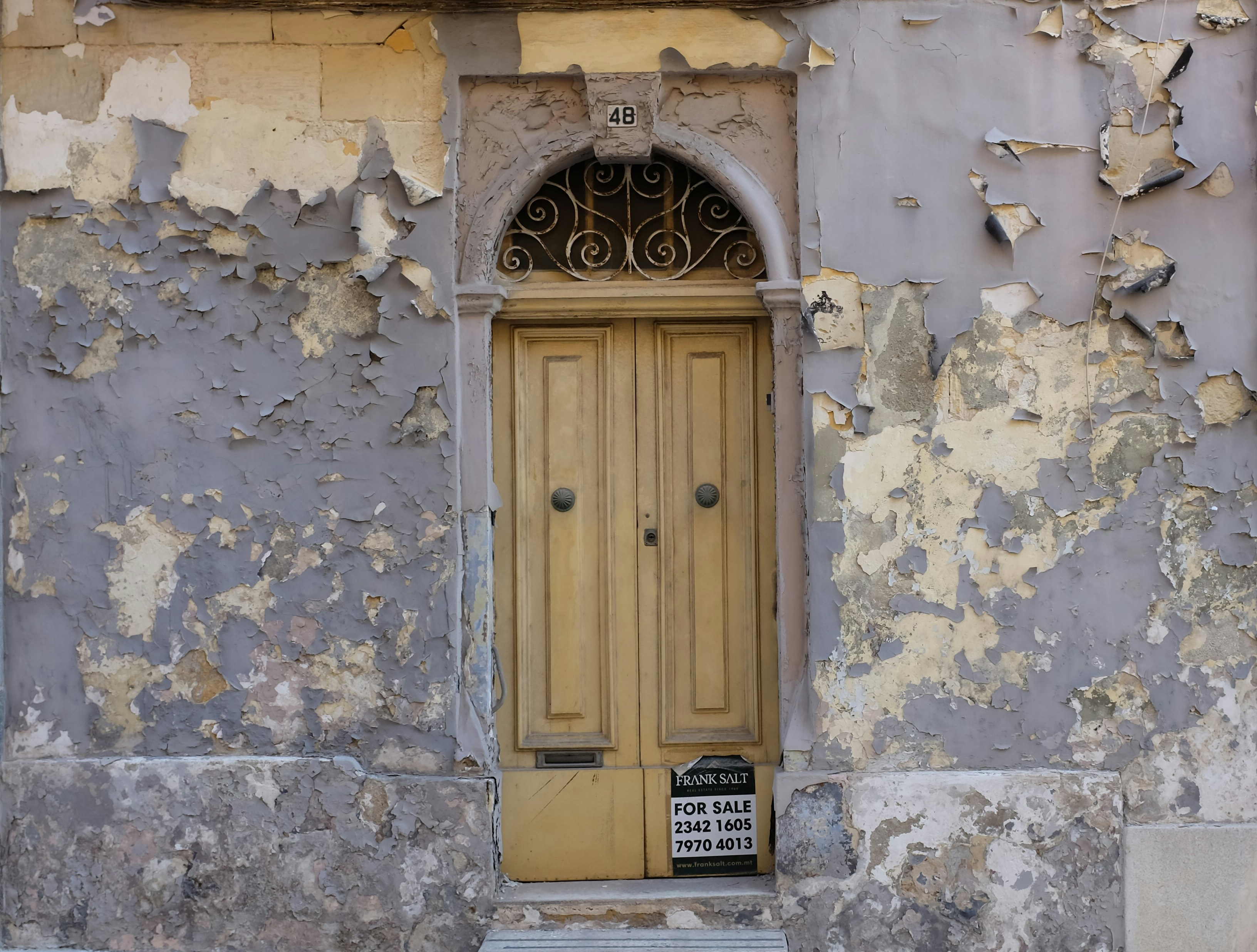 an old building with peeling paint and a yellow door