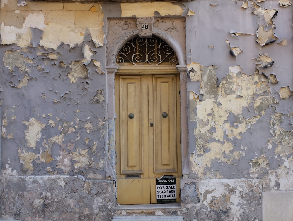 an old building with peeling paint and a yellow door