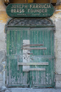 Artisans carefully restoring a weathered wooden door in Cunziria