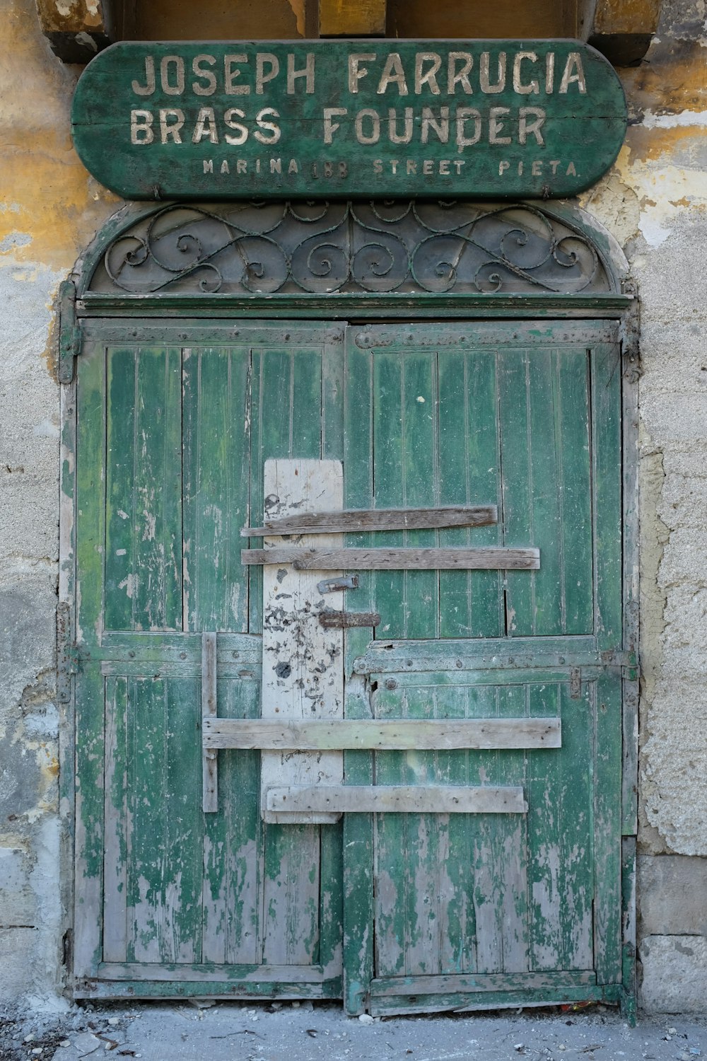 an old green door with a sign above it