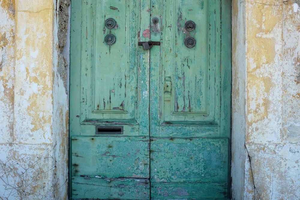 uma porta verde com duas maçanetas sobre ela