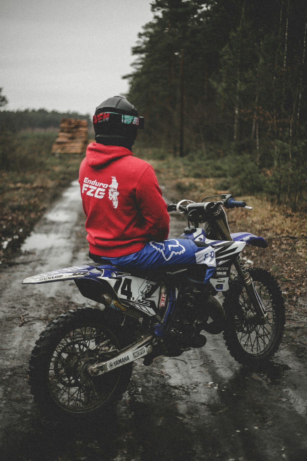 a man riding a dirt bike on a wet road