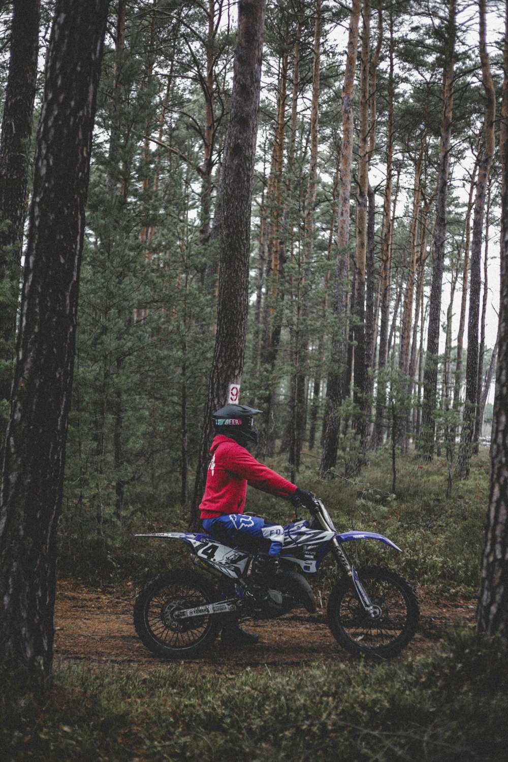 a man riding a dirt bike through a forest