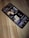 A smartphone is lying on a wooden surface, displaying a music streaming app that shows playlists and songs on the screen.