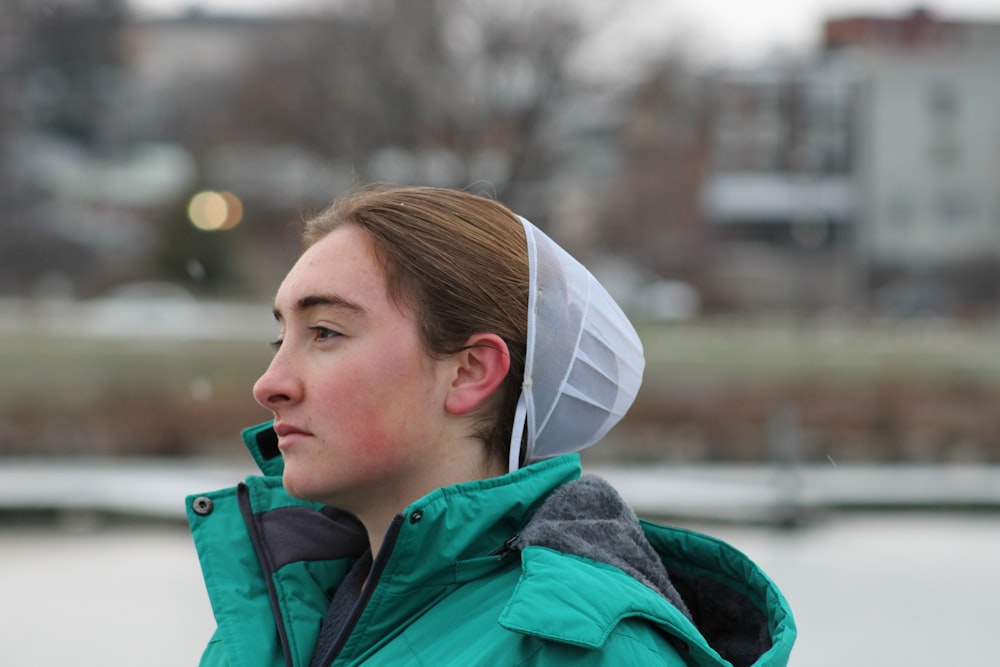 a woman wearing a green jacket and a white hat