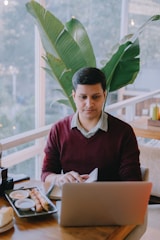 A cheerful traveler practicing Spanish on a tablet while sitting at a sunny café abroad.