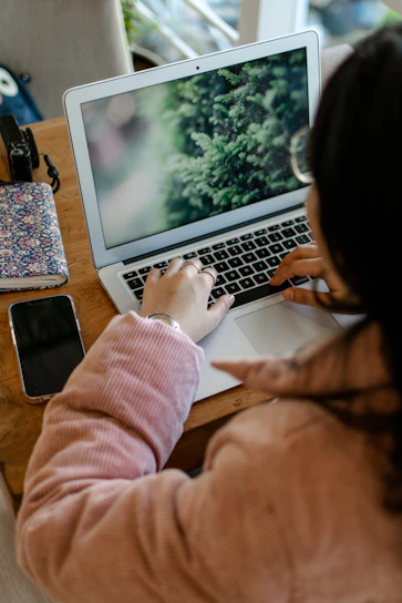 a woman sitting at a table using a laptop computer