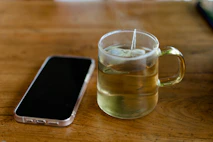 A peaceful setting with a cup of tea and a phone, inviting calm conversations.
