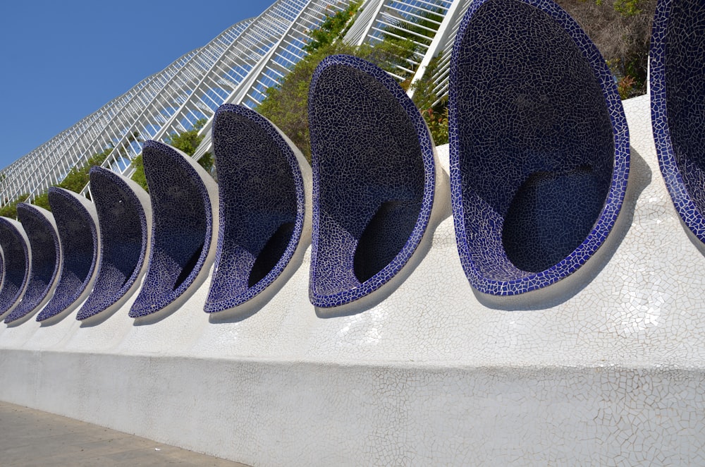 a row of blue vases sitting on top of a cement wall